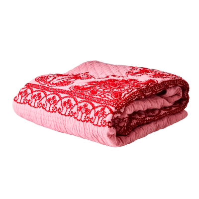 A pink blanket with red floral embroidery.